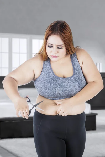 Fat woman cutting her big tummy — Stock Photo, Image