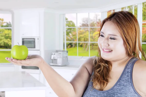 Dikke vrouw houdt groene appel — Stockfoto