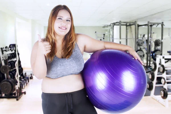 Gruba kobieta posiada fioletowy fitness ball — Zdjęcie stockowe