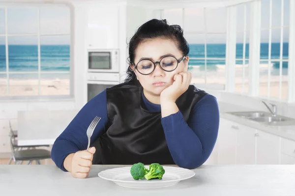 Tlustá žena hledá brokolice — Stock fotografie