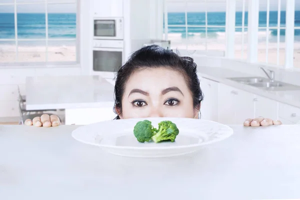 Fat woman peeping broccoli