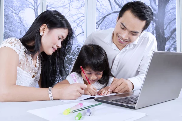 Chica estudiando con los padres en casa — Foto de Stock