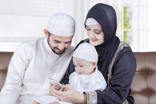 Famille musulmane heureuse utilisant un smartphone — Photo
