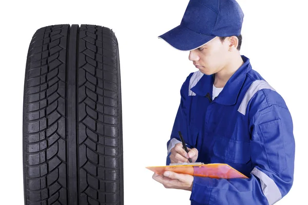 Mechanic checking a tyres in the studio — Stock Photo, Image