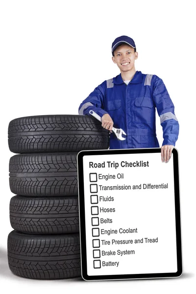 Mechanic standing with board and tyres — Stock Photo, Image