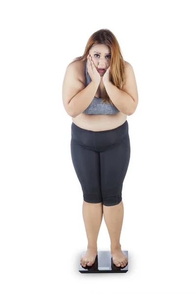 Толстая женщина, стоящая на весах — стоковое фото