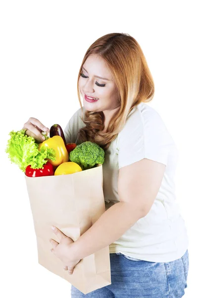 Kvinna håller grönsak på papperspåse — Stockfoto
