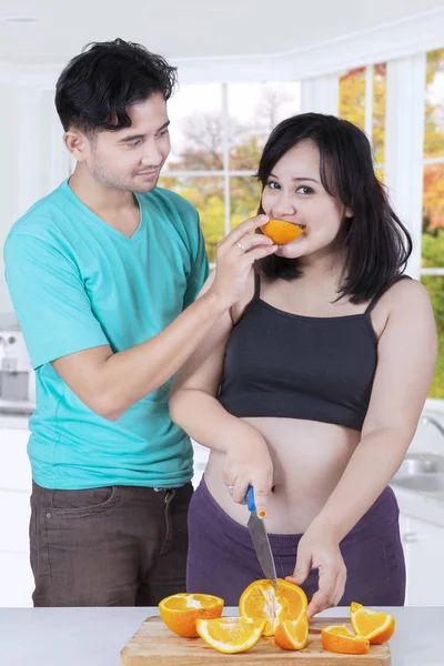 Молодая пара со свежим апельсином — стоковое фото