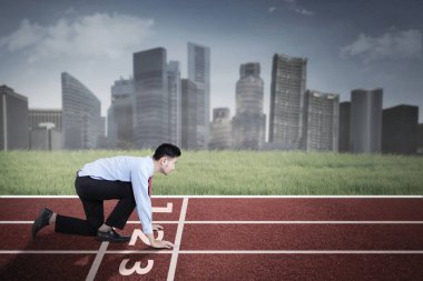 Başlangıç pozisyonda diz çökmüş işadamı