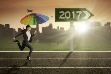 Yolda bir şemsiye kullanarak iş kadını