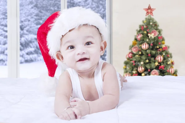 Bebê com chapéu de santa e árvore de natal — Fotografia de Stock