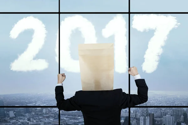 Affärsman bära kartong med nummer 2017 — Stockfoto