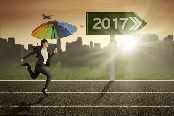 Yolda bir şemsiye kullanarak iş kadını