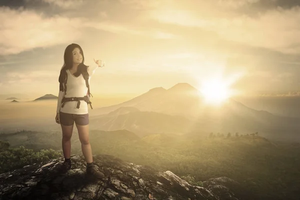 Mujer excursionista mostrando el pulgar en el acantilado — Foto de Stock