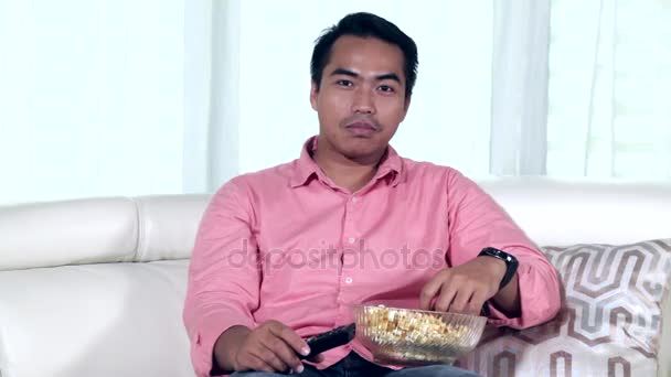Man titta på tv och äter popcorn — Stockvideo