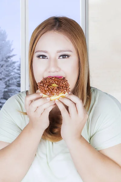 Mooie vrouw eet donut — Stockfoto