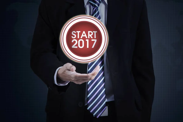 Uomo d'affari con pulsante di avvio e numero 2017 — Foto Stock