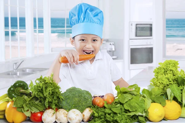 Kind eet groenten in de keuken — Stockfoto