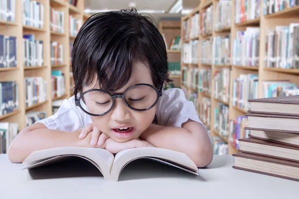 Criança gosta de ler livros na biblioteca — Fotografia de Stock