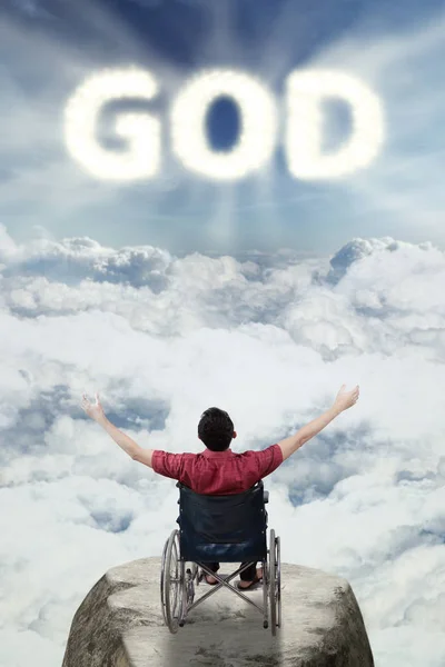 Мужчина-инвалид с текстом бога в горах — стоковое фото