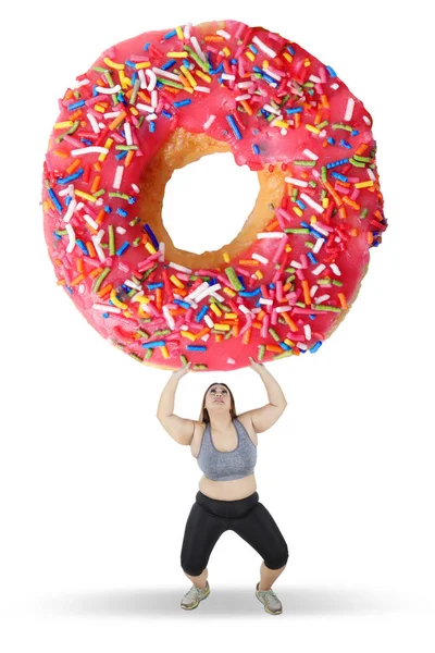 Dicke Frau beim Heben großer Donut — Stockfoto