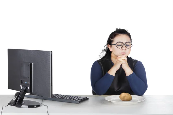 Dikke vrouw bidt met aardappel op plaat — Stockfoto