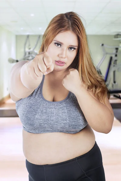 피트 니스 센터에 펀칭 하는 뚱뚱한 여자 — 스톡 사진