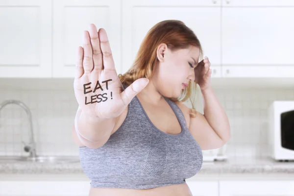 Mulher gorda com comer menos texto na mão — Fotografia de Stock