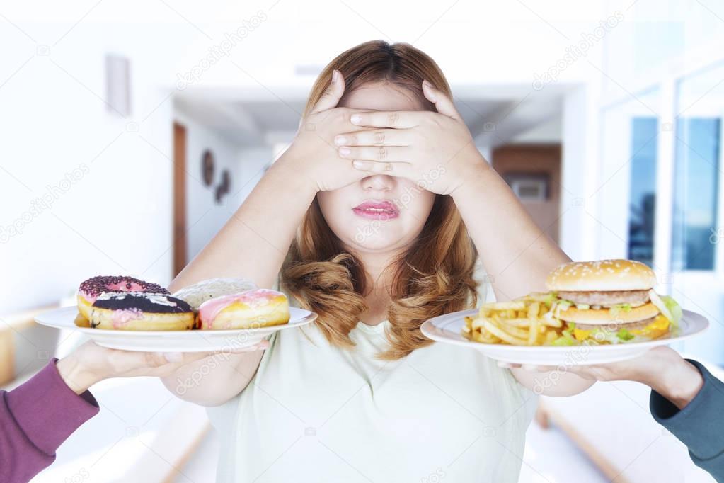Fat woman closed eyes for junk food
