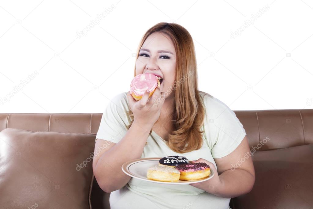 Fat woman eats donuts