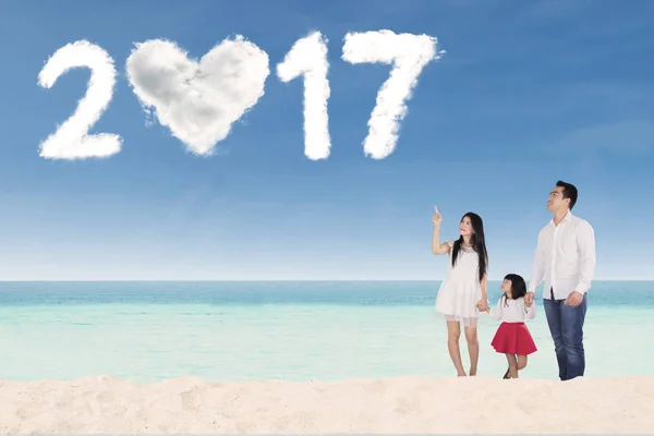 Happy family with number 2017 on beach — Stock Photo, Image