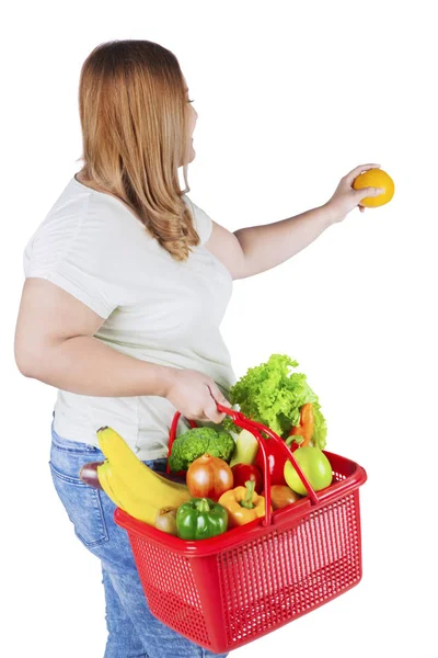 Zwaarlijvige vrouw houdt fris oranje — Stockfoto