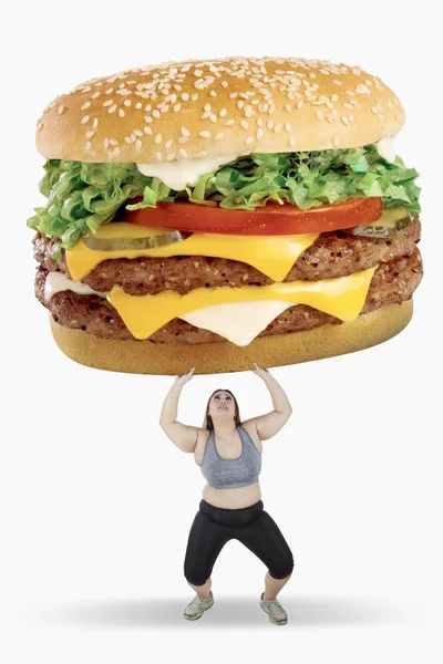 Femme obèse soulevant gros hamburger — Photo