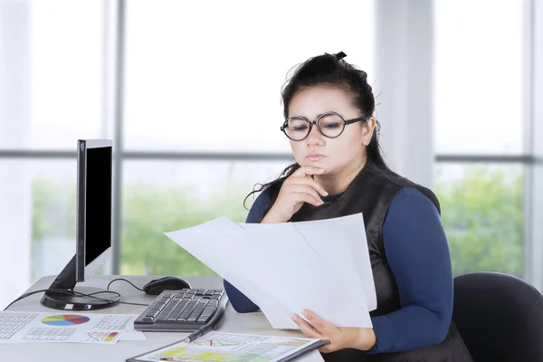 Nachdenkliche Geschäftsfrau hält Papiere — Stockfoto