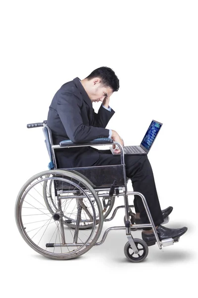 Hombre de negocios estresante con silla de ruedas y portátil —  Fotos de Stock