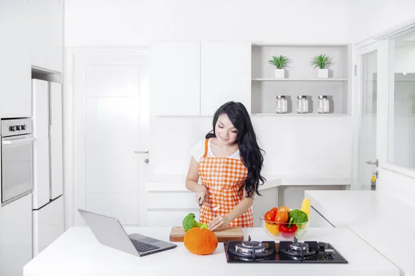 Vrouw hakken broccoli in de keuken — Stockfoto