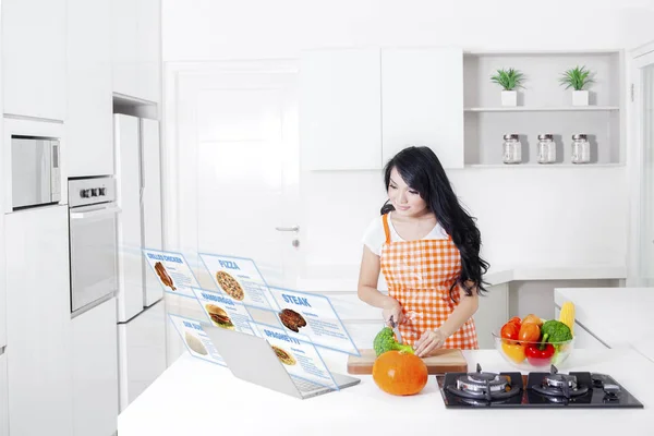 Vrouw met virtuele recepten in keuken — Stockfoto