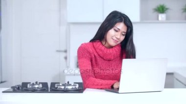   Neşeli kadın dizüstü mutfakta kullanır.