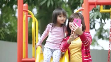   Çocuk ve annesi alarak selfie slayt üzerinde