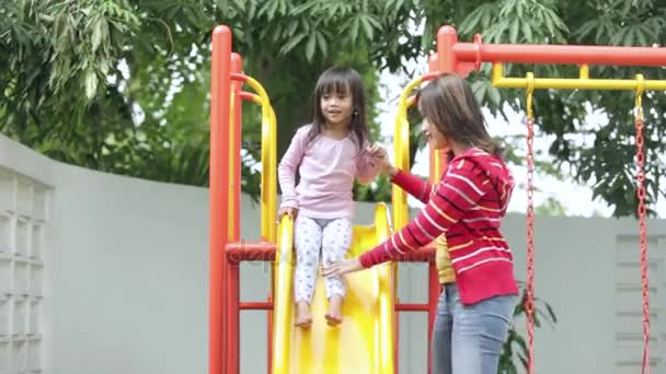 Child playing on slide with her mother — Stock Video