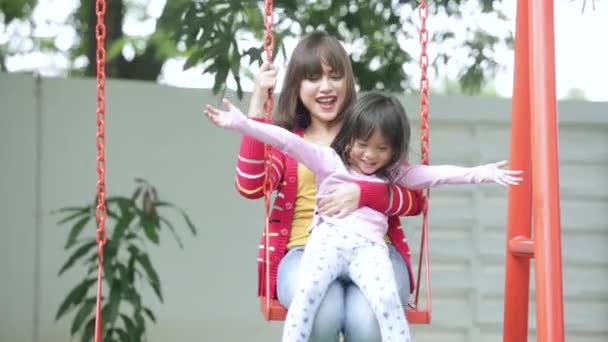 Little girl and mother playing a swing — Stock Video