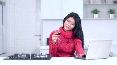   Dizüstü bilgisayar ile kadın kırmızı şarap içer