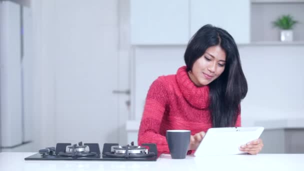 Женщина с планшетом и кофе на кухне — стоковое видео