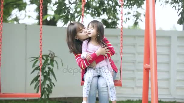Jovem mulher beijar sua filha no swin — Vídeo de Stock