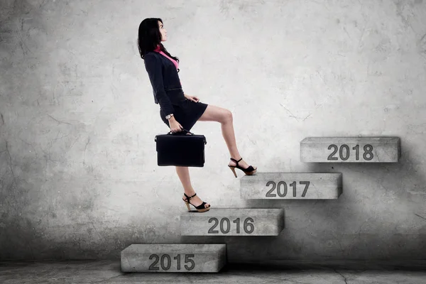 Businesswoman walks on stairs to numbers 2017 — Stock Photo, Image