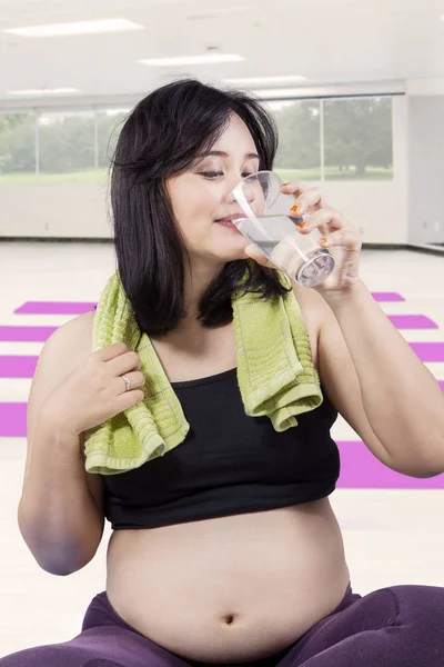 La madre embarazada bebe agua en el gimnasio — Foto de Stock