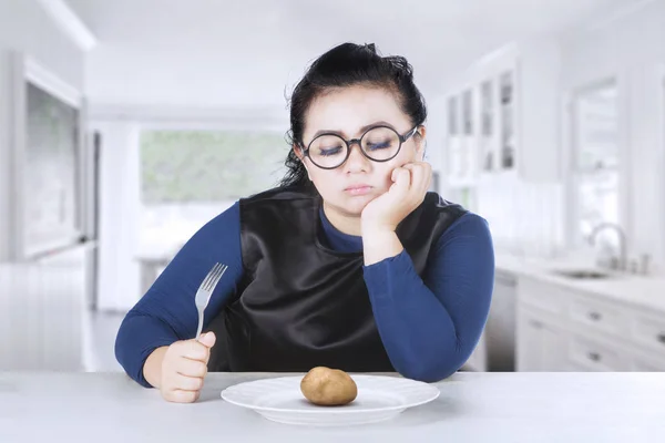 Mulher gorda olhando ferveu batata na cozinha — Fotografia de Stock