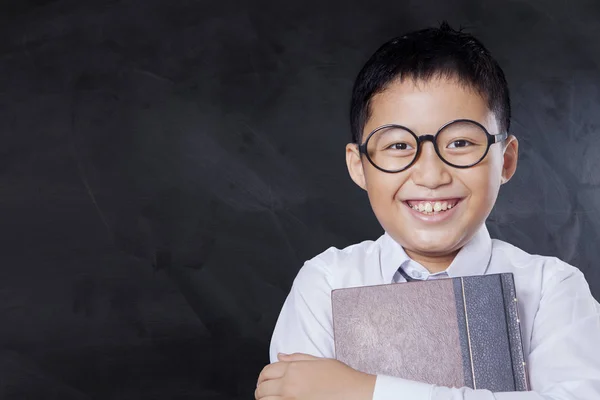 Fröhlicher Junge mit Buch und Tafel — Stockfoto