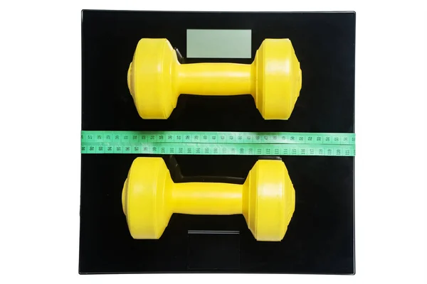 Measuring tape and barbells with weigher — Stock Photo, Image