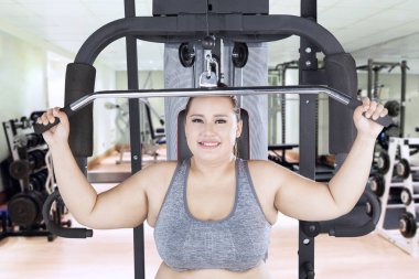 Obez kadın fitness Center'da kablo makine ile